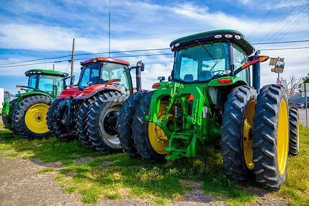 A lineup of quality-tested used farm tractors from leading manufacturers parked in a professional export yard. Auto Tires Co Ltd supplies compact, utility, and agricultural tractors for retail and wholesale customers worldwide.